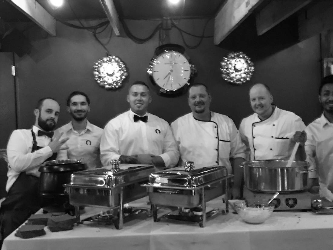 Küchen- und Servicecrew hinter dem Buffet